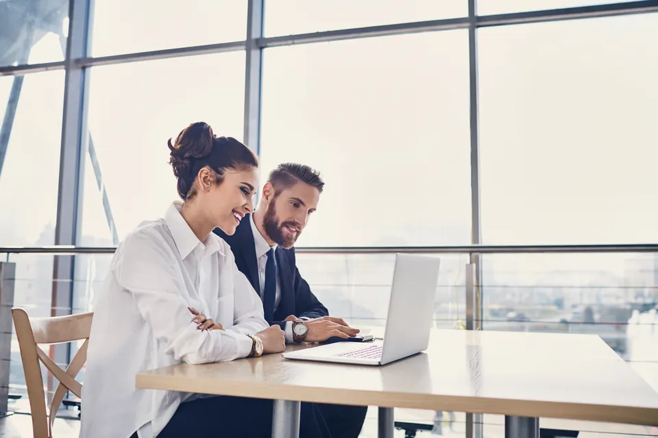 An entrepreneur and adviser review application documents together